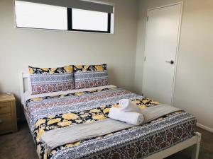 奥克兰Modern & Luxurious Home 2的一间卧室配有带毛巾的床