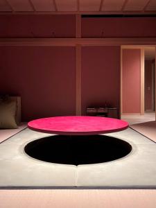鹿儿岛萌蘖　露天風呂とサウナがある現代の湯治場的一间房间中间的一张粉红色桌子