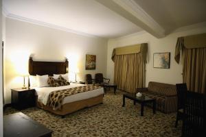 伊斯兰堡Hotel Hillview Islamabad的酒店客房,配有床和沙发