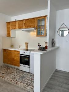贝斯和圣阿纳斯泰斯Appartement au cœur de la station de Super-Besse的厨房配有木制橱柜和白色台面