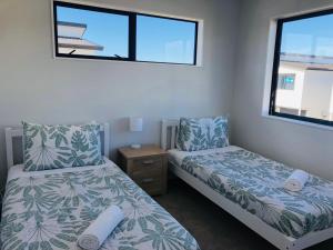 奥克兰Modern & Luxurious Home 3的一间卧室设有两张床和窗户。