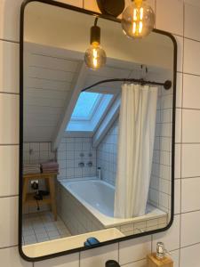 格雷茨里德Gemütliches Loft的带浴缸的浴室内的镜子