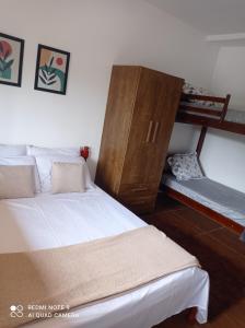 坎波斯杜若尔当Cantinho Feliz a 900m do Capivari的一间卧室设有两张床和木制橱柜