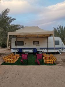 欧拉Amazham Caravan的配有椅子的露营车、帐篷和一群橘子
