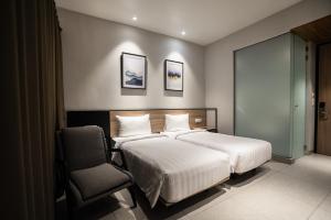 当格浪CONJIOO HOTEL at JAKARTA AIRPORT的酒店客房,配有两张床和椅子