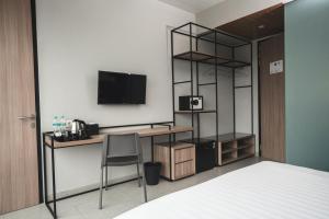 当格浪CONJIOO HOTEL at JAKARTA AIRPORT的客房设有书桌、电脑和电视。