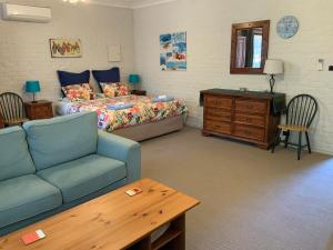 CarramarBentworth Lodge的一间卧室配有一张床、一张沙发和一张桌子