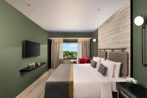 西隆Vivanta Meghalaya Shillong的酒店客房,配有床和电视