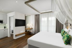 桑托德Mövenpick Balaland Resort Lake Balaton的酒店客房,配有床和电视