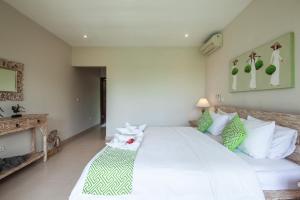 孟威Villa Pascaline的卧室配有白色大床和绿色及白色枕头