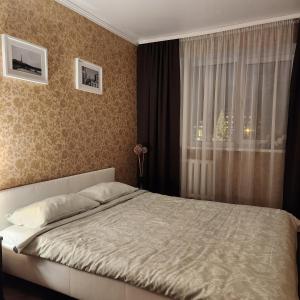 叶尔加瓦Charme apartment的一间卧室设有一张大床和一个窗户。