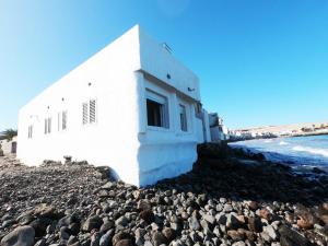 大加那利岛拉斯帕尔马斯La casa de la playa的海边岩石上的白色建筑