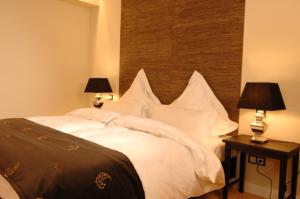 汉堡泽培林汉堡酒店的一间卧室配有一张带白色枕头的床和两盏灯。