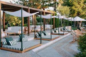 玛利亚Cretan Malia Park a Member of Design Hotels的庭院里摆放着一组椅子和遮阳伞