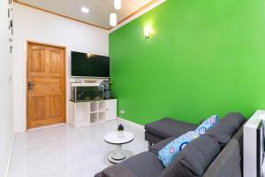 乌库拉斯Maafolhey Han'dhaan - Ukulhas的带沙发和绿色墙壁的客厅