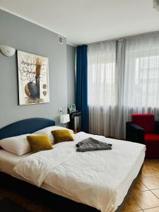 比得哥什埃尔达酒店的一间卧室配有一张大床和一张红色椅子