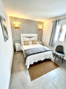 宏达海滩Luxury Beach Apartments Diama的一间卧室配有一张大床和一把椅子
