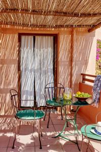 赫索尼索斯科图洛法里村庄假日俱乐部酒店的庭院配有桌椅和玻璃桌及椅子