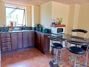 格拉鲍Essenhout Self-catering Accommodation的厨房配有柜台和带凳子的桌子