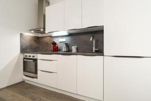 布拉格Apartments / 10 min from center / O2 ARENA的厨房配有白色橱柜和水槽