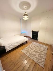 莱尼斯公园Spacious flat with patio garden的一间卧室配有一张床,铺有木地板。