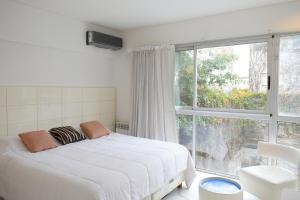 布宜诺斯艾利斯Syrah Studios的卧室设有白色的床和大窗户
