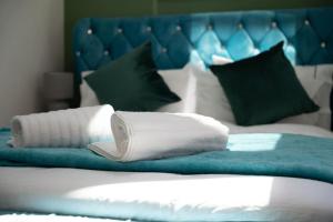 荷尼湾Stylish Beachfront Bolthole with Stunning Sea Views and Luxury Touches的一张带白色枕头和蓝色床头板的床