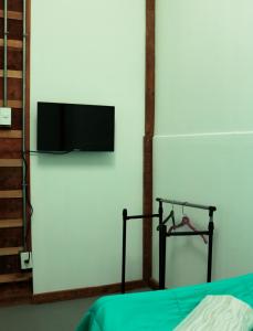 蓬塔阿雷纳斯Casa Bike的一间卧室配有一张床,墙上配有电视