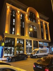 MidyatAsur Imperıal Hotel的一座大型建筑,前面有汽车停放