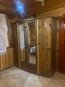 布克维Гостинний Двір Вишня的一间设有木墙的客房和一间带镜子的客房