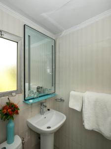 Sere Kunda NDingSunset Beach Hotel的白色的浴室设有水槽和镜子