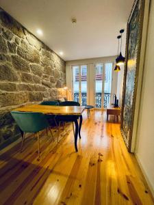 波尔图Oporto Chic & Cozy - Mercadores的一间设有木桌和石墙的客房