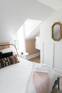 皮克顿Downtown Picton 2-Bedroom Boho Suite!的卧室配有白色的床和镜子