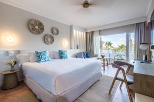 EsteponaMETT Hotel & Beach Resort Marbella Estepona的一间带白色大床的卧室和一间客厅