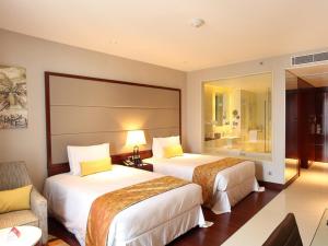 科钦科钦皇冠假日酒店的酒店客房,配有两张床和椅子