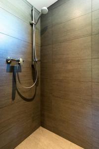 SachrangAlpenchalet Sachrang的带淋浴的浴室(带木墙)