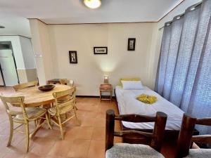 斯瓦科普蒙德Bushbabies-Inn Self-Catering Accommodation的配有一张床和一张桌子及椅子的房间
