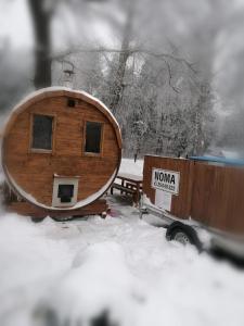 GardeneApartamenti pie Lienes的一辆卡车旁边的雪地里的小木屋