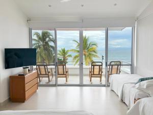 托卢Quinta Del Mar El francés的带电视的卧室和海景阳台。