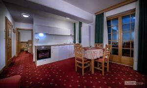 兹雷切Garni Hotel Pod Roglo Boharina 2的厨房配有桌子和桌椅