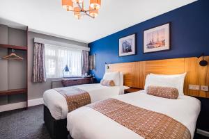 朴次茅斯The Red Lion by Innkeeper's Collection的两张位于酒店客房的床,拥有蓝色的墙壁