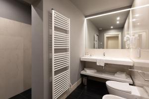 帕尔马Palazzo Liberati Apartments的一间带卫生间、水槽和镜子的浴室