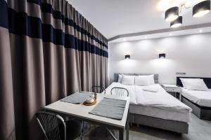 华沙Magnetic apartment Nowogrodzka B的一间卧室配有两张床和一张桌子及椅子