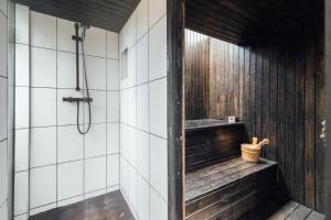 芬奇利Stylish 2 Bedroom Flat with a Private Sauna的一间带淋浴的浴室和一张长凳
