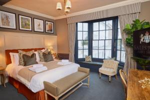 赫特福德索尔兹伯里纹章酒店的酒店客房带一张大床和一把椅子