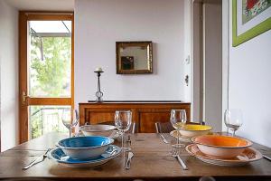 PisanoIl Gelsomino - Terrace Country House的一张木桌,上面放着碗和酒杯