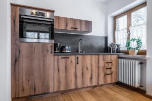 伦格里斯Haus Hohenwiesen的一个带木制橱柜和水槽的厨房