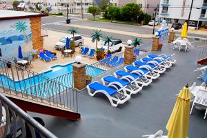 北怀尔德伍德Florentine Family Motel的一组躺椅和遮阳伞,位于游泳池旁