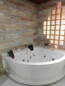 皮塔利托Hotel Colonial Andino - Parque principal de Pitalito的配有木制墙壁的浴室内的一个大型白色浴缸