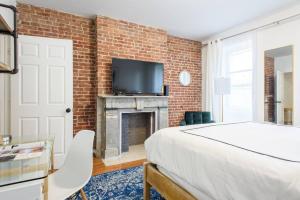 纽约454-3W PRIME location 2BR Newly Furnished sleeps 5的一间卧室设有砖墙、一张床和一个壁炉